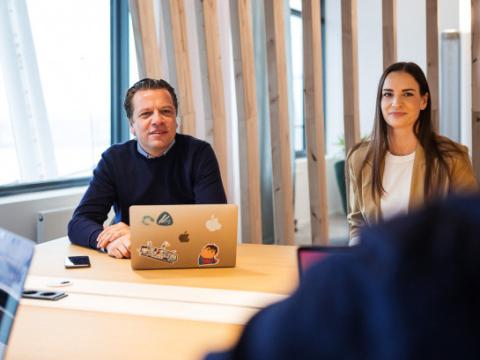 MSH 23 Mann mit Laptop und Frau an Schreibtisch in Gesprächssituation 