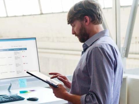XMS 23 Mann mit Tablet vor Schreibtisch