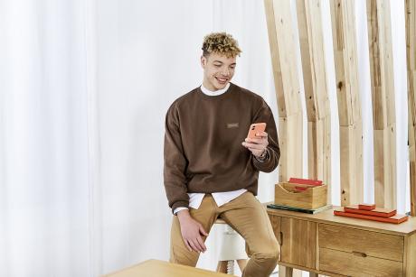 Mann auf Hocker mit Handy