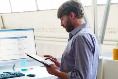 XMS 23 Mann mit Tablet vor Schreibtisch
